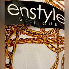 A dress with a Medusa head print and gold chains. This loose-fitting T-shirt